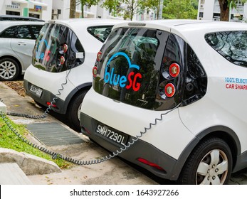 SINGAPORE – 30 JAN 2020 – Electric cars owned by the electric carsharing company BlueSG charging their batteries at an electric charging station. The charging cables are clearly visible.