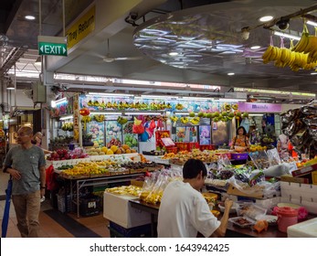 SINGAPORE – 4 JAN 2020 – A Fruit Seller Takes A Lunch Break At A Fruit Stall At The Ang Mo Kio Wet Market In Singapore, Southeast Asia. Tropical Fruits And Groceries Are On Display 