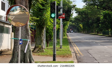 SINGAPORE - 4 JUN 2022: The Traffic Light Is Green, Meaning That Vehicles Can Proceed On The Upper Thomson Road To Yishun. A Convex Mirror Gives A Wider View Of People Or Cars At Corners.