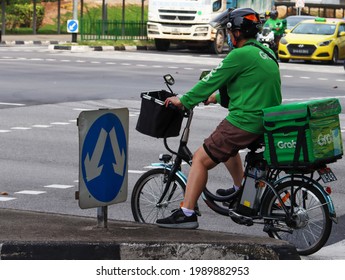 SINGAPORE - 6 JUN 2021. The  Bicycle With The Step Through Frame Is Suitable For The Grabfood Food Delivery Rider As He Requires Frequent Dismounting. A Rear Bracket Secures His Food Delivery Bag.