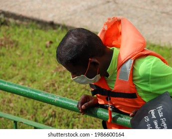 SINGAPORE - 6 JUN 2021: A Migrant Worker From South Asia Wears A Reusable Face Mask Properly Amid Covid-19 Outbreak. He Works For The Utility Company To Clear The Storm Water Canal In Plaza Singapura.