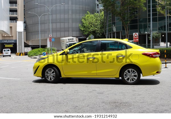 SINGAPORE - 7 MAR 2021: LIVERIES refer to the\
colours in which the vehicle, aircraft or product of a company are\
painted. This taxi is painted in the City Cab livery, but has NO\
brand name visible.