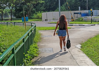 SINGAPORE - 7 NOV 2021: A Foreign Domestic Worker Walks To Cross The Zebra Crossing At Yio Chu Kang Crescent To The Bus Stop During Her Sundays Off Work. 