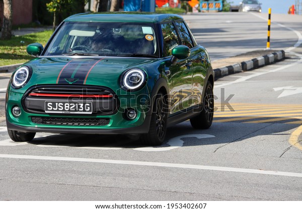 SINGAPORE - 9 APR 2021. The older model Mini Clubman is\
rarely seen. It has a black plastic part across the radiator\
grille.  The 2021 model has a full radiator grill with no black\
plastic part. 