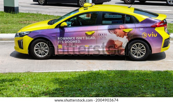 SINGAPORE - 9 JUL 2021. Taxis display vehicle\
wrap advertisements to generate additional revenue for the owner as\
rental income has had decreased owing to Covid-19 curbs. A Viu App\
is advertised.