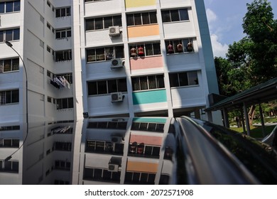 SINGAPORE - 9 NOV 2021: Song Birds In Cages Are Hung Outside The Living Room Window Of The Tampines North Housing Board HDB Flat. They Receive Fresh Air And Afternoon Sunlight For A While.