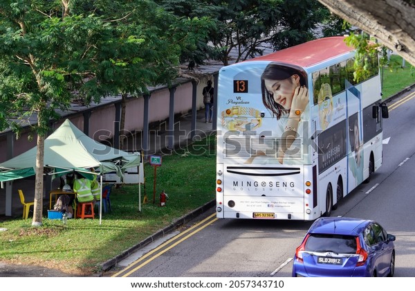 SINGAPORE - 9\
OCT 2021: A public bus has an attractive Ming Seng Goldsmith\
vehicle wrap advertisement which is an effective mobile billboard\
ad and also earns income for the owner.\
