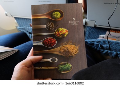 Singapore - April 13 2018 : Singapore Airlines menu book, held by hand