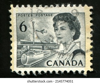 SINGAPORE – APRIL 14, 2022: A Stamp Printed In Canada Shows Queen Elizabeth II, Transport Plane, Ship, Railroad And Truck, Circa 1970