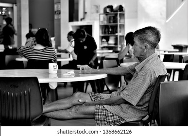 Singapore - April 4 2019: Elderly Chinese Man Relaxing At Table In Local Hawker Centre With Cup Of Coffee At Commonwealth, Singapore 