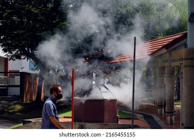 Singapore Aug2021 Heavy smoke ash from concrete burner (dust specks). Residents burn joss paper money as offerings to dead during 7th month Hungry Ghost Festival. Pollution to environment a concern
