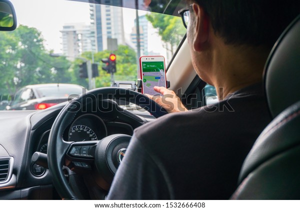 Singapore- August 10, 2019 :\
Point of view image Unidentified man drive a grab car on the\
Singapore City.