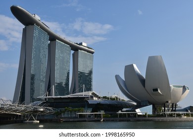 Singapore, Singapore - August 22, 2019: Marina Bay Sands, including the ArtScience Museum, designed by Moshe Safdie, with the Helix Bridge (left), designed by Cox Architecture, Architects 61 and Arup.