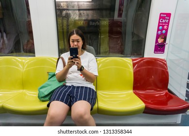 SINGAPORE - CIRCA OCTOBER, 2018:   A Lady Playing Smart Phone While Inside The Train In Singapore. MRT Is A Major Component Of The Railway System In Singapore.