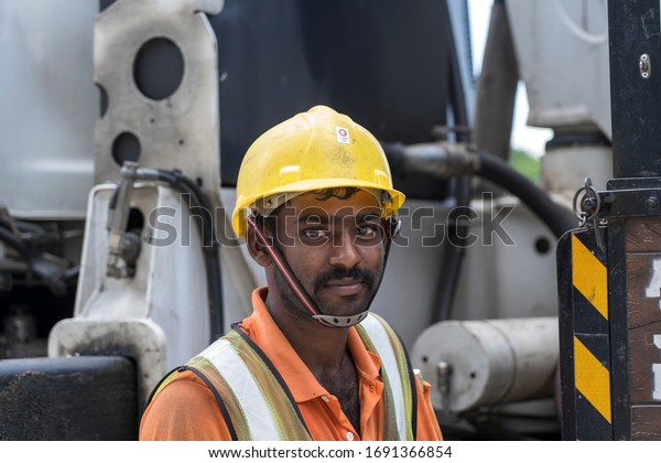 Singapore city, Singapore - february 28, 2020\
: A migrant worker poses for a photo on a city centre construction\
site in Singapore. The SE Asian city state has a significant\
migrant worker\
population