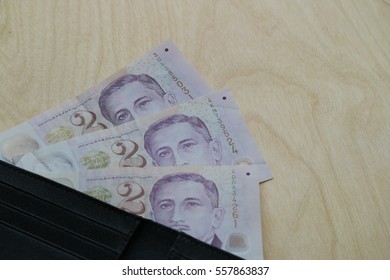 Singapore Dollar Cash In Wallet On Wooden Bakground, Finance Concept