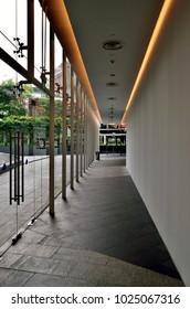 Singapore - February 14 2018: Modern Office Corridor With Glass Wall, Sleek Gray Wall And Overhead Strip Lighting