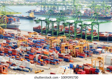 Singapore - February 17, 2017: Container terminal at the Port of Singapore. Cargo ships docked in harbor. Ship-to-shore (STS) gantry cranes loading and unloading vessels at shipping yard.