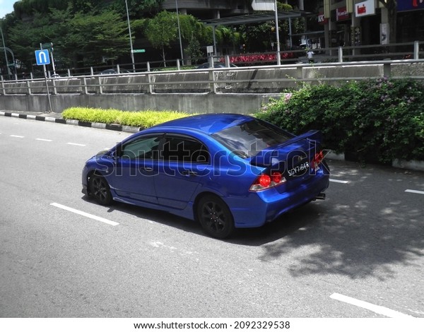 Singapore, february 17 2020: private front-wheel fwd
drive blue metallic color japanese midsize old compact sedan Honda
Civic 8 Gen FD popular sport car made in Japan drive on sunny
highway street 
