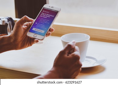 Singapore. February 3, 2017: Young Woman Holding Iphone Open Music Apple App On The Screen. Music Apple Appis The Popular Online Video-sharing Website.