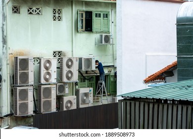 Singapore, January 7,2021: Man Servicing The Compressor Of Aircon Unit. 