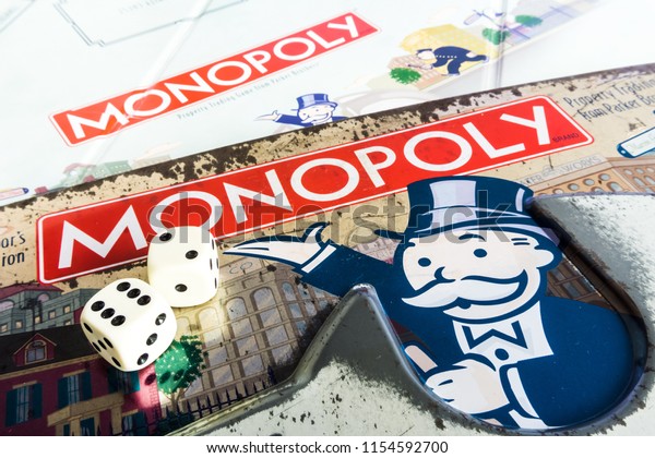 Singapore - Jul 25, 2018:  Monopoly Board Game\
close up with the box, board and dices. The classic real estate\
trading game from Parker Brothers was first introduced to America\
in 1935.