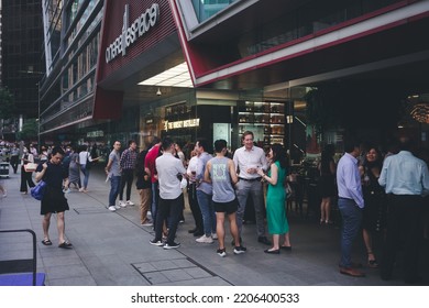 SINGAPORE - JULY 27, 2022 : Businessman And Businesswoman 
Hang Out After Work Near Singapore Central Business District, A Modern Financial Building District Area In Raffle Place, Singapore.