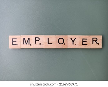 Singapore - Jun 6 2022: The Word EMPLOYER Spelt Out With Wooden Scrabble Letter Tiles