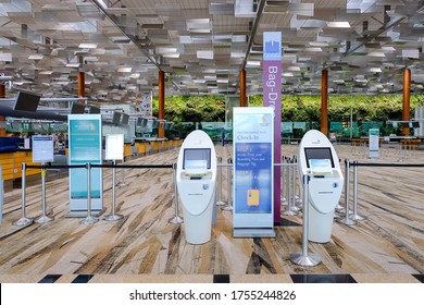 Singapore Jun2020 Self check in kiosks and information panels at Changi Airport Terminal 3; bag drop area. No travellers during covid-19 coronavirus outbreak; empty hall; advertisement mock up display
