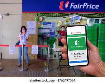 Singapore Jun21 2020 Show Of SafeEntry (digital Contact Tracing App) On Phone At NTUC Fairprice Supermarket. Woman Scanning Entry Code In The Background. Circuit Breaker; Coronavirus Outbreak; Phase 2