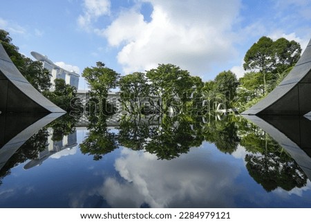 Singapore landscape. Beautiful wide angle landscape view with the reflection of green trees and landmarks of Singapore.