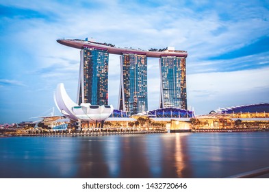 SINGAPORE, SINGAPORE - MARCH 2019: Skyline of Singapore Marina Bay at night with Marina Bay sands, Art Science museum and tourist boats