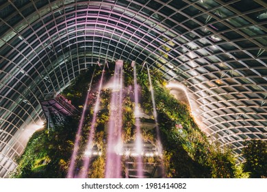 SINGAPORE, SINGAPORE - MAY 26, 2021: The Falls Inside Flower Dome Greenhouse At Night Time In Singapore