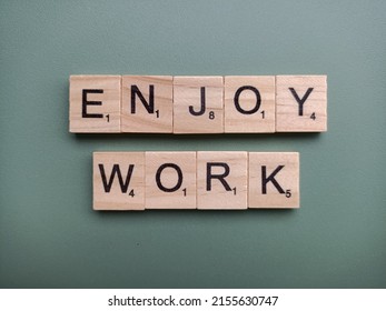 Singapore - May 8 2022: The Word ENJOY WORK Spelt Out With Wooden Scrabble Letter Tiles