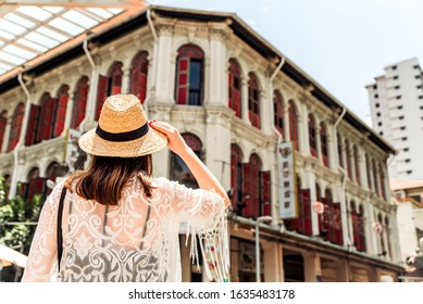 Singapore, Oct 2019: Woman Tourist Wearing Straw Hat And Boho Style Outfit Admiring Colonial City Architecture In Chinatown. Tourism Concept