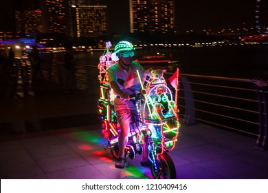 SINGAPORE, SINGAPORE - OCT 6, 2018: Man riding a LED light bicycle at Marina Bay.