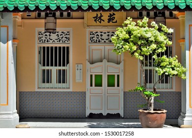 Singapore - October 11 2019: Colourful Entrance To Traditional Peranakan Shop House With Bifold Doors, Chinese Wall Tiles And Pot Plant In Historic Spottiswood Park