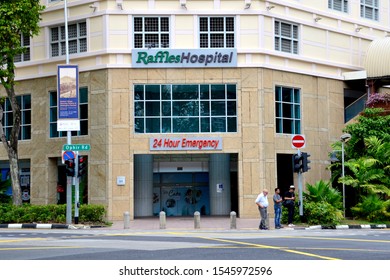 SINGAPORE, OCTOBER 2019: Pedestrians Waiting To Cross The Road At The Ophir Road Entrance To The 24 Hour Emergency Department Of Raffles Hospital In Singapore. 