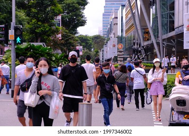Singapore Sep 2020 People wearing face masks crossing a road (selective focus). Crowd picks up in Orchard Road during Phase 2 after circuit breaker; Covid-19 coronavirus outbreak