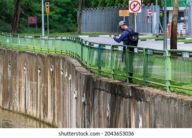 SINGAPORE-17 SEP 2021: A man  throws in his fishing line onto the YCKC storm water canal which has the backflow of fresh water and fishes from the Seletar Simpang Kiri River. Fishing is good exercise.