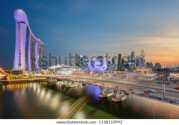 SINGAPORE-JULY 08 : Singapore city skyline with\
movement of the cars during twilight time on July 08, 2018 at\
Marina Bay.