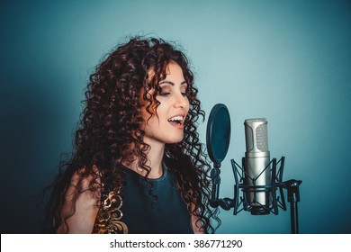 Singer. Closeup Portrait Head Shot Sexy Beautiful Happy Young Woman Lady Girl Singing With Microphone Smiling Isolated Green Background Wall. Positive Human Emotion Expression Feeling Life Perception 