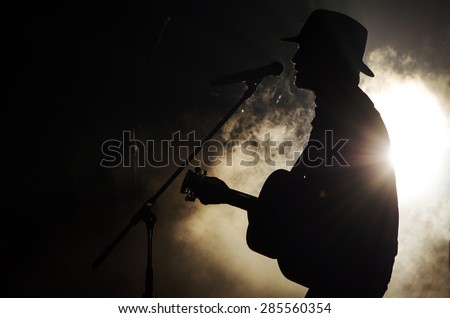 A singer man silhouette playing guitar