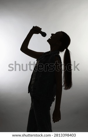 Singer with microphone performing on light grey background