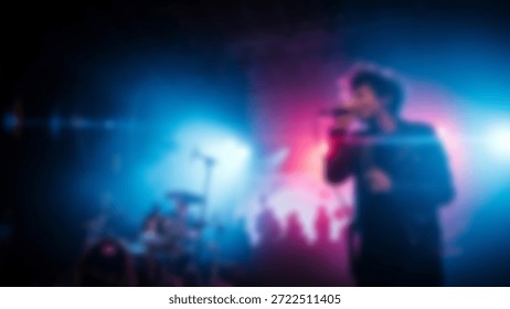 Singer performs on stage with dramatic colored lights and crowd.