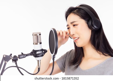 Singer Woman Singing Sad Song Or Broken Heart Music And Crying During Sing A Song In Recording Studio. Asian Young Female Wear Headphones And Using Microphone, Pop Filter For Singing And Record Sound 