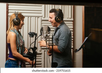 Singers laughing while recording a song in the studio - Powered by Shutterstock