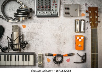 Singer-Songwriter and home recording, lifestyle music concept. Flat lay with musician and sound engineer stuff like guitar, mixer, microphone, keyboard, cables, headphones and so on. Vintage filtered