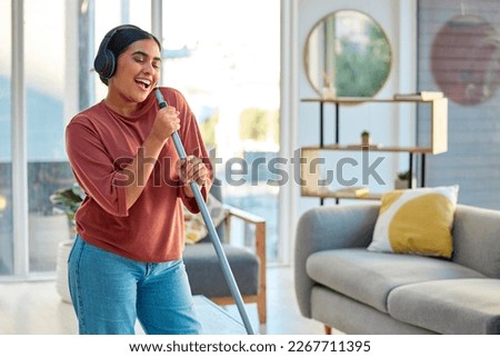 Singing, cleaning and headphones of a woman with music working in a home dancing with happiness. Spring cleaning, cleaner and happy person sing and dance with a mop in living room listening to audio