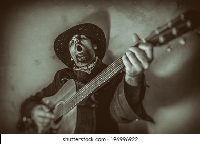Singing Old West Cowboy With Guitar. Old west cowboy singing and playing a guitar, edited in vintage film style.